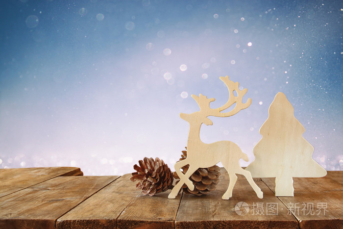 抽象的形象木制装饰圣诞树，驯鹿和松树球果木桌和圣诞假期散景灯