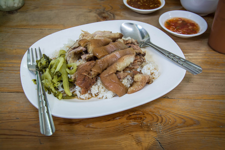 炖猪腿，水稻与侧碗木制的桌子上。泰国菜