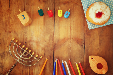 顶视图图像的犹太节日光明节与烛台 传统烛台 甜甜圈和木制陀螺 陀螺。复古的滤波的图像