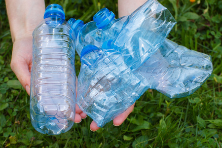 妇女手里拿着塑料瓶矿泉水, 乱扔环境