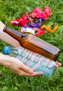 塑料和玻璃瓶在妇女手中乱扔环境