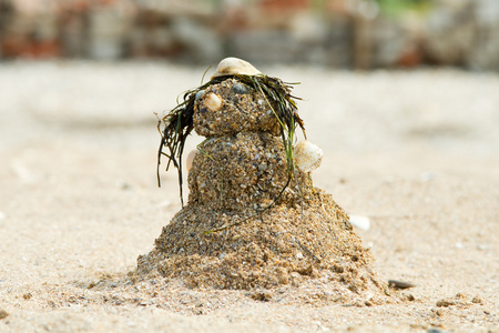 一个雪人的雕像, 由沙子, 贝壳和海草在嘘