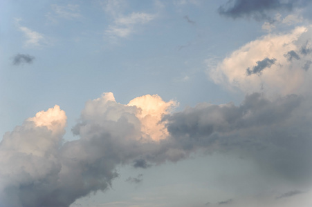 被太阳照亮的蓝天背景上的白云. 晚上的时间.照片