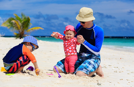 父亲和孩子们去做热带海滩沙子城堡