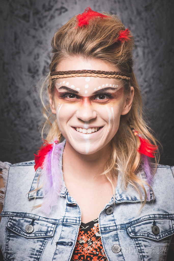 美国印第安人,涂着油漆的脸,伪装着,微笑着,看着