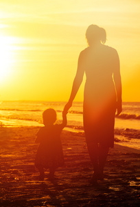 母亲和小女儿在日落时分散步