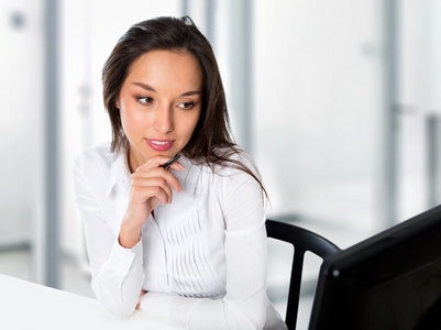 在办公室使用电脑的年轻的商界女子肖像