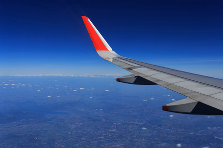 一架飞机在云层上面飞翔的翅膀照片