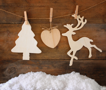 木制装饰圣诞树和驯鹿挂上一根绳子在木制背景的形象