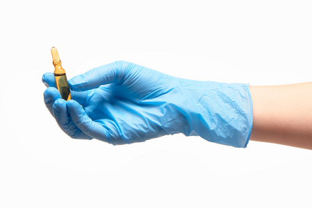 女医生的手在蓝色消毒的外科手术手套控股棕色玻璃安瓿用一种药物的特写