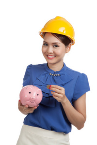 亚洲工程师女人与硬币和小猪存钱罐