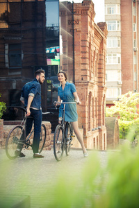 年轻夫妇坐在一辆自行车在城市对面