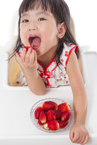 亚洲的中国小女孩吃草莓