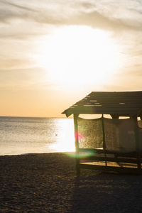 躲避在日落时太阳的海滩小屋