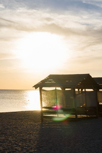 躲避在日落时太阳的海滩小屋