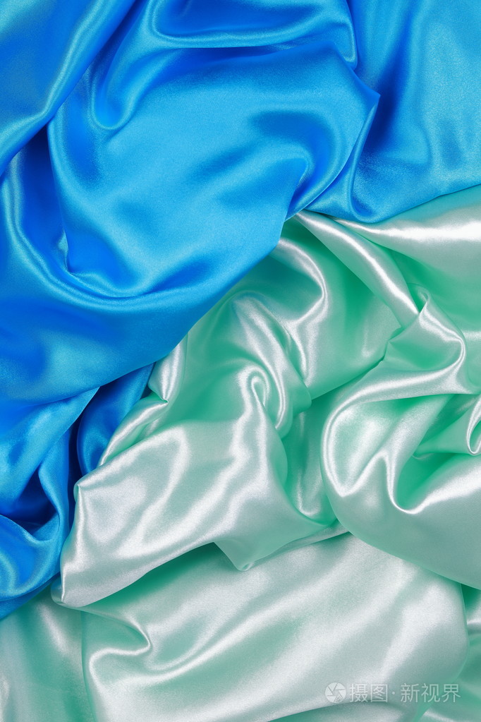 蓝色和浅绿色丝缎布波浪褶皱质地回来的