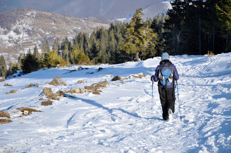 女人在冬天在山里徒步旅行