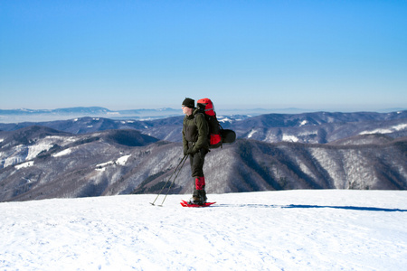 在山里徒步旅行带着背包和帐篷雪的冬天