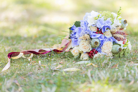 铺设在绿色草地上的夏天的婚礼花束。春天