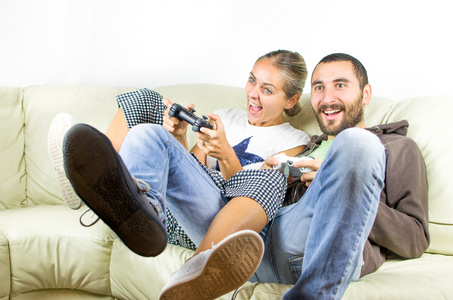 对夫妇获取兴奋开心玩视频游戏在沙发上