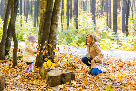 快乐家庭母亲和小女儿在秋天走上玩