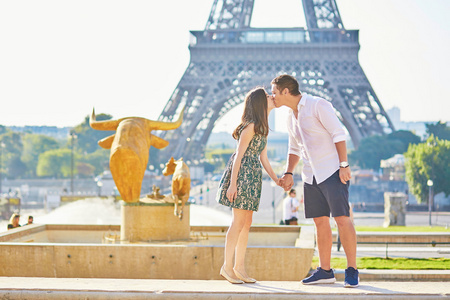 年轻对浪漫的情侣接吻艾菲尔铁塔附近
