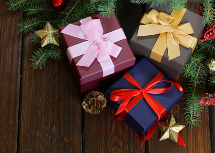 礼品盒用节日彩带和圣诞装饰品木制背景上
