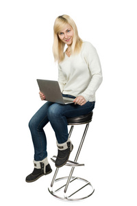 坐在高脚椅的商界女强人，在笔记本电脑上工作