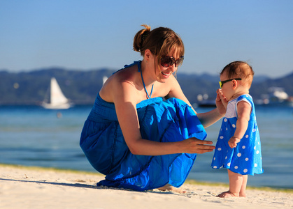 母亲和热带海滩上的小女儿