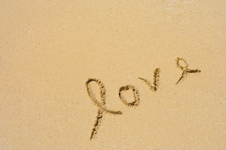 概念或概念手作出或手写爱在一个充满异国情调的小岛的海滩上的沙子中的文本
