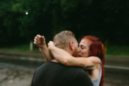 美丽的夫妇在雨中亲吻