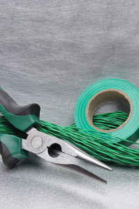 绿色的电动工具和金属表面上的电缆