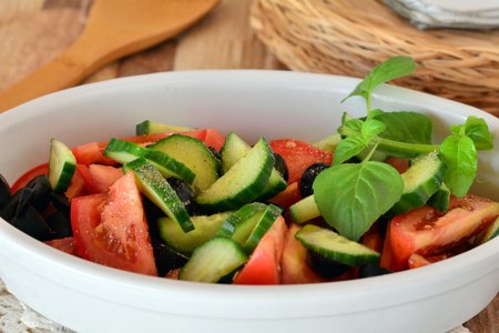 健康的蔬菜色拉，配黄瓜，西红柿上白色的瓷器碗