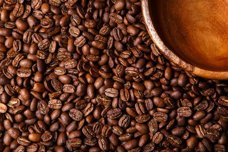 褐色咖啡豆背景与木盘子里特写