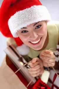礼品盒红色背景上圣诞老人的帽子上快乐的女孩