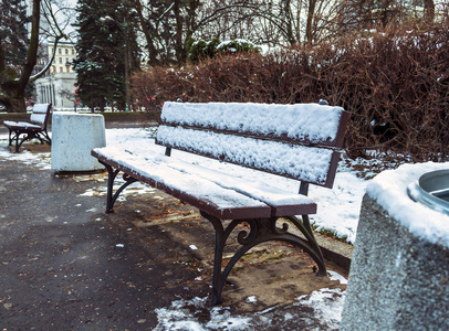 在装满着雪的冬天城市公园长椅