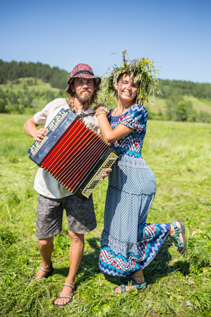 在俄罗斯传统情侣连衣裙在草地上