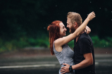 美丽的夫妇在雨中拥抱