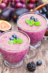 与紫色的水果和浆果的新鲜健康得稀烂鸡尾酒