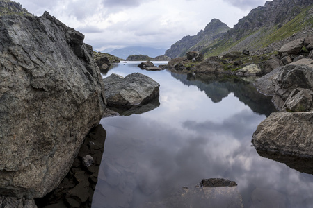 全景景观与湖山，巨大的岩石和石头的海岸和白云倒影