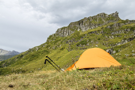 橙色的帐篷里的山和登山杖