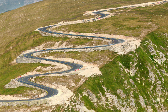 在阳光在弯弯曲曲的柏油马路上驾驶