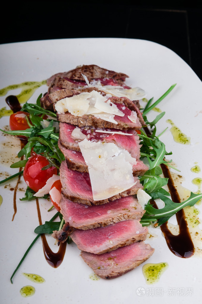 牛排配上一盘蔬菜和奶酪