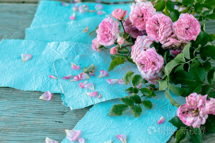 粉色玫瑰用木制的桌子上的文件