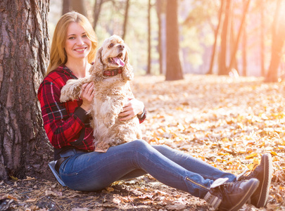 年轻漂亮的女人和她的狗 美国可卡犬 在外面摆姿势下降时间