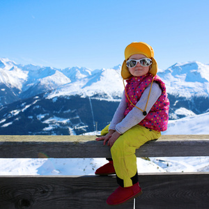 高山滑雪度假村享受寒假的小女孩