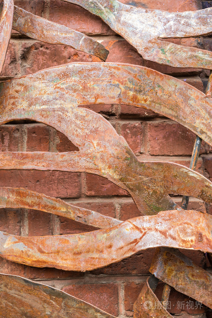 扭曲和生锈的铁片旧红砖砌成的墙上照片-正版商用图片1kb68l-摄图新视
