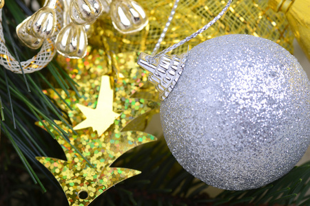 节日的金色圣诞装饰，蜡烛，白球，青翠的松树树枝，靠得很近
