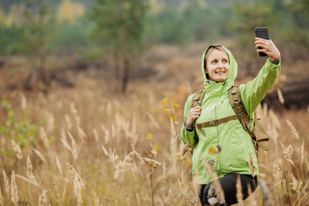 旅行者女人正在自拍照在森林里