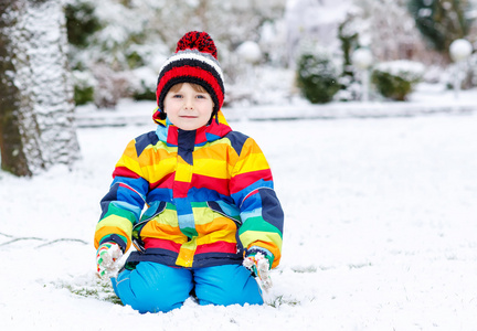 滑稽的学龄前男孩穿五颜六色的衣服高兴雪，供电系统